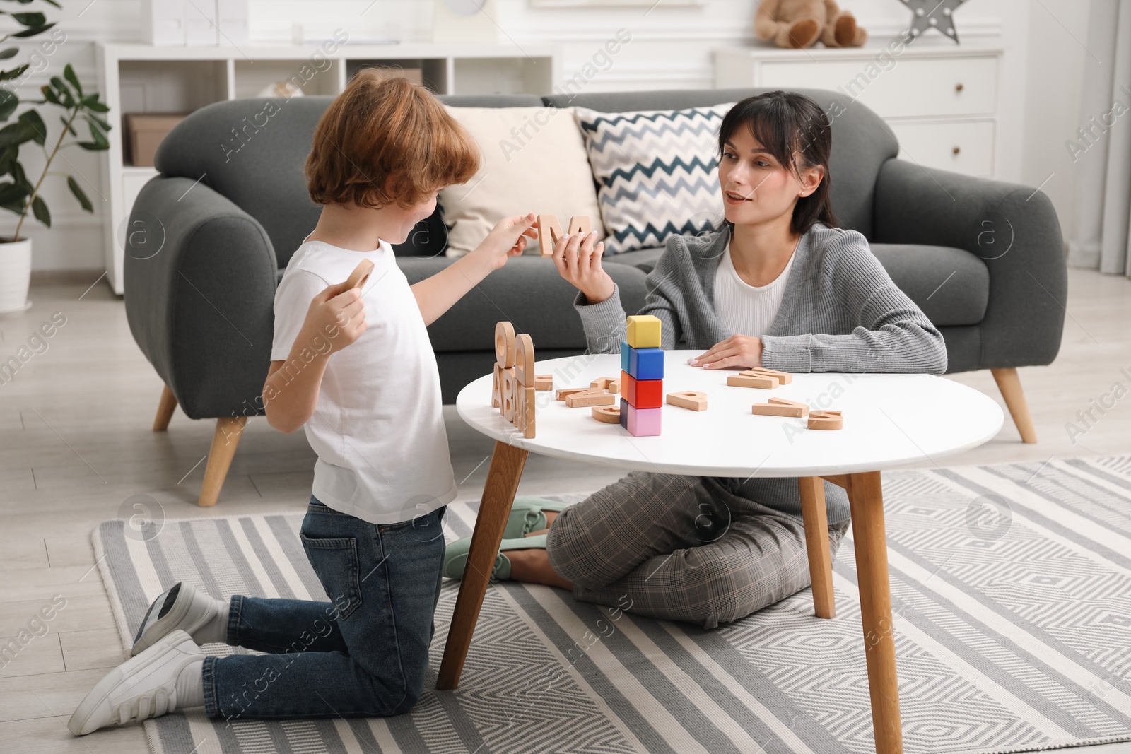 Photo of Psychologist evaluating boy's cognitive functions at table in office