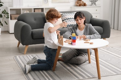 Photo of Psychologist evaluating boy's cognitive functions at table in office