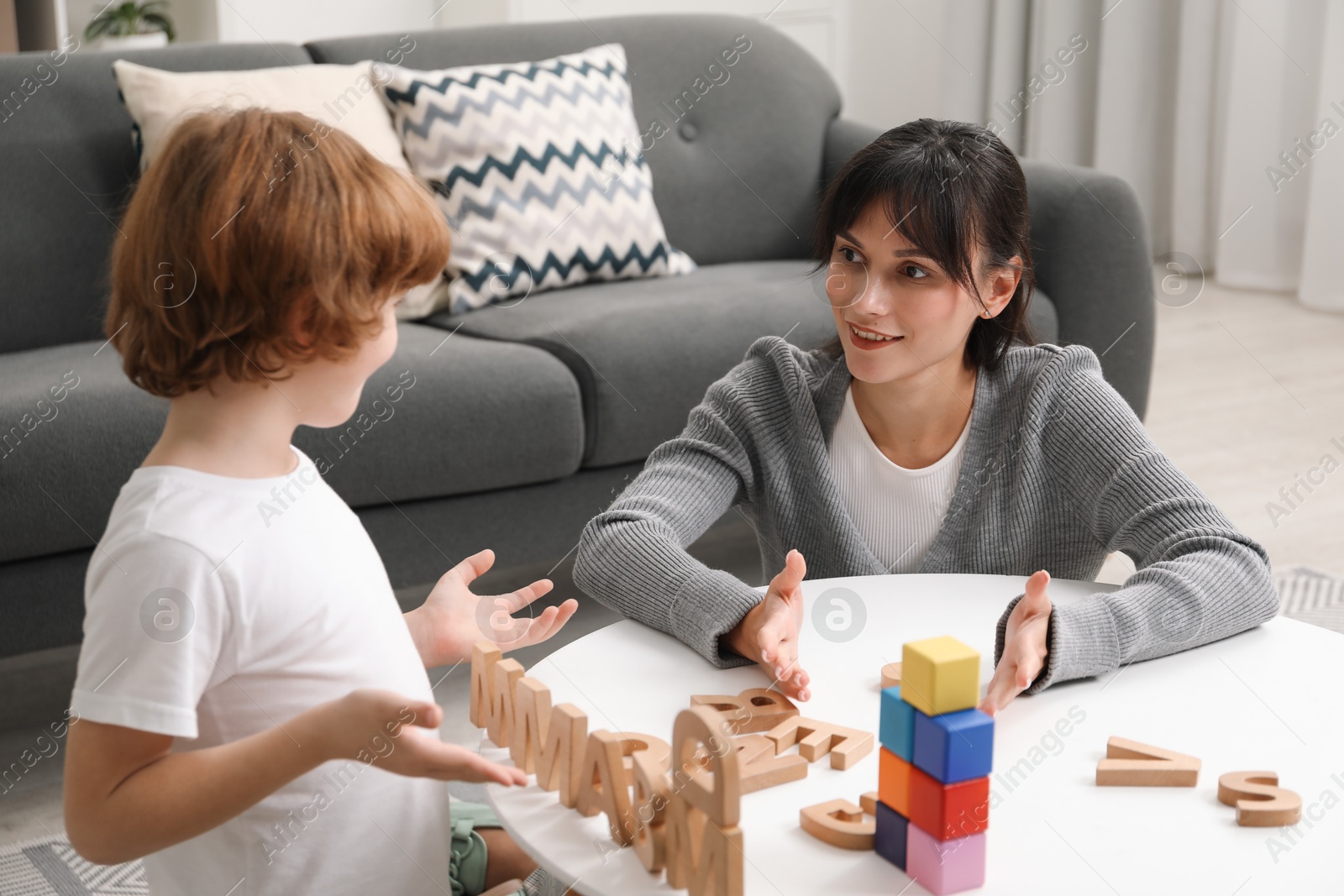 Photo of Psychologist evaluating boy's cognitive functions at table in office