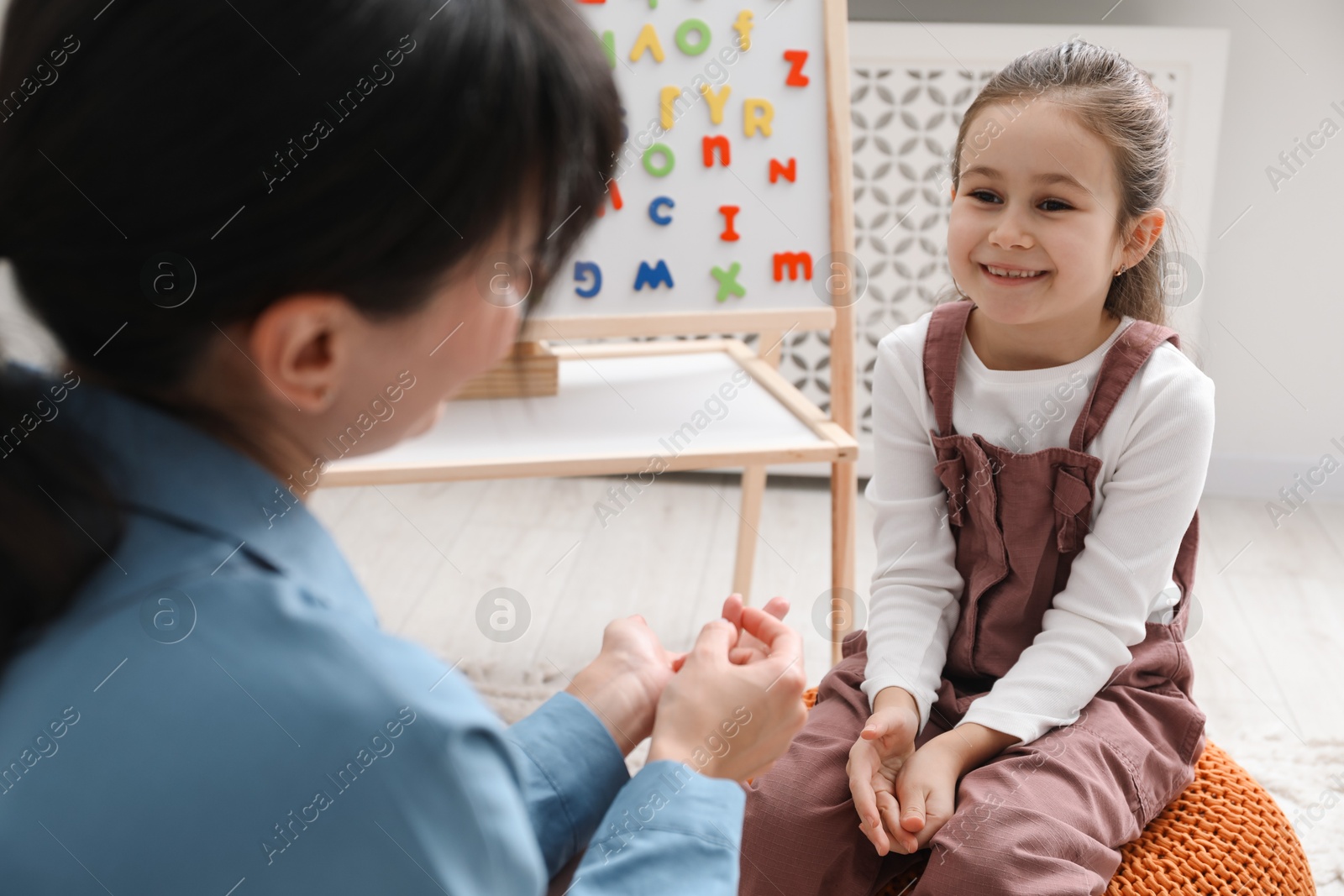 Photo of Little girl having consultation with psychologist in office