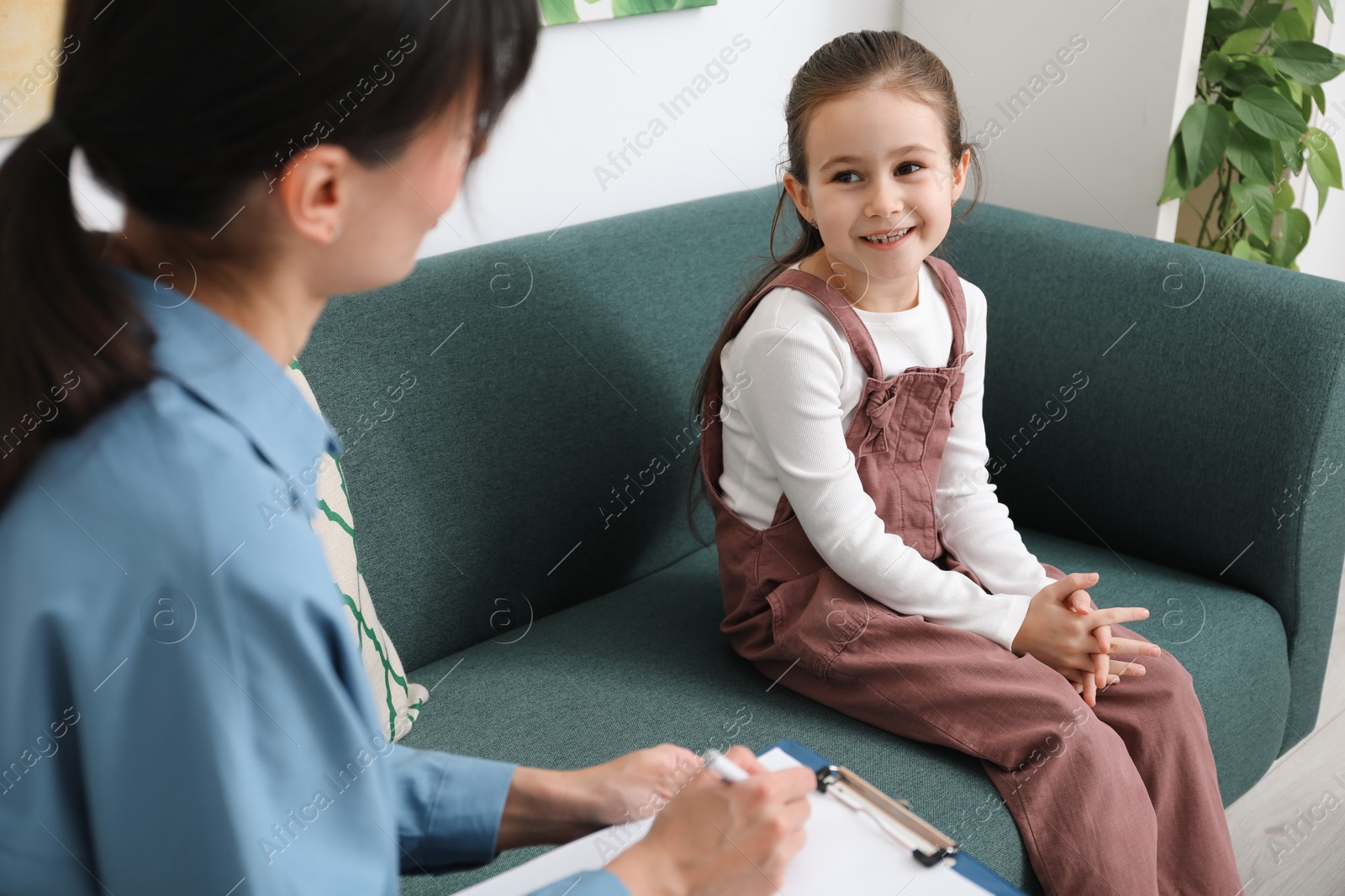 Photo of Little girl having consultation with psychologist in office