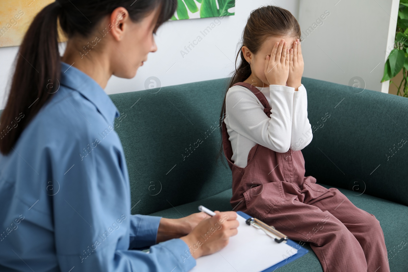 Photo of Upset girl having consultation with psychologist in office