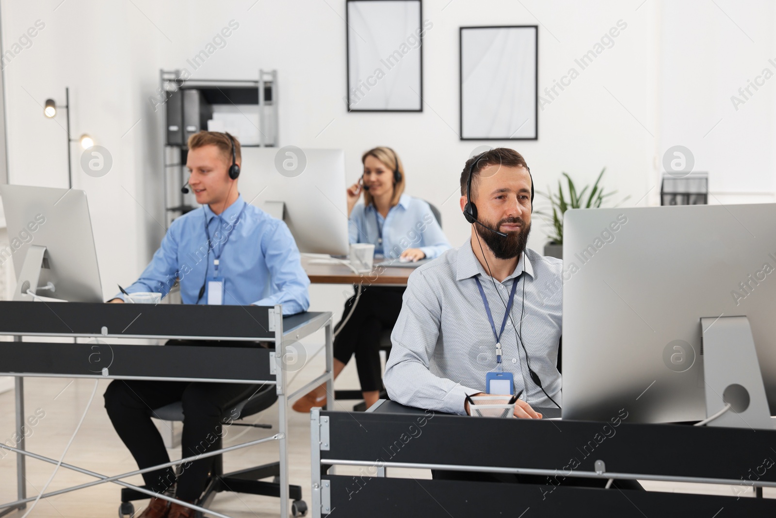 Photo of Technical support call center. Team of operators working in office