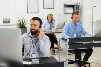 Photo of Technical support call center. Team of operators working in office