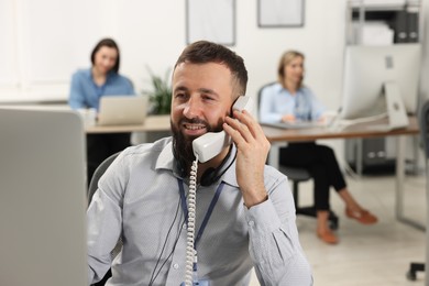 Photo of Technical support call center. Smiling operator working in office