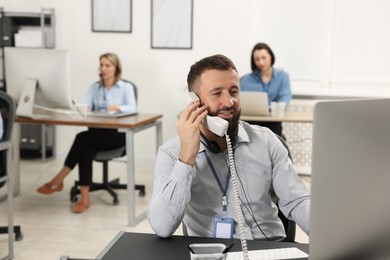 Photo of Technical support call center. Smiling operator working in office