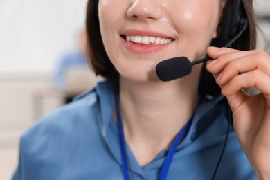 Photo of Technical support call center. Smiling operator working on blurred background, closeup