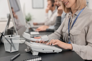 Photo of Technical support call center. Team of operators working at table in office, closeup