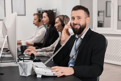 Photo of Technical support call center. Team of operators working in office