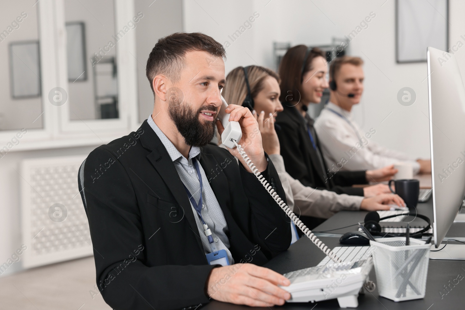 Photo of Technical support call center. Team of operators working in office