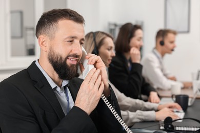 Photo of Technical support call center. Team of operators working in office