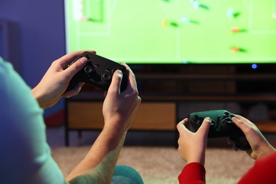 Photo of Father and his son playing video game at home, closeup