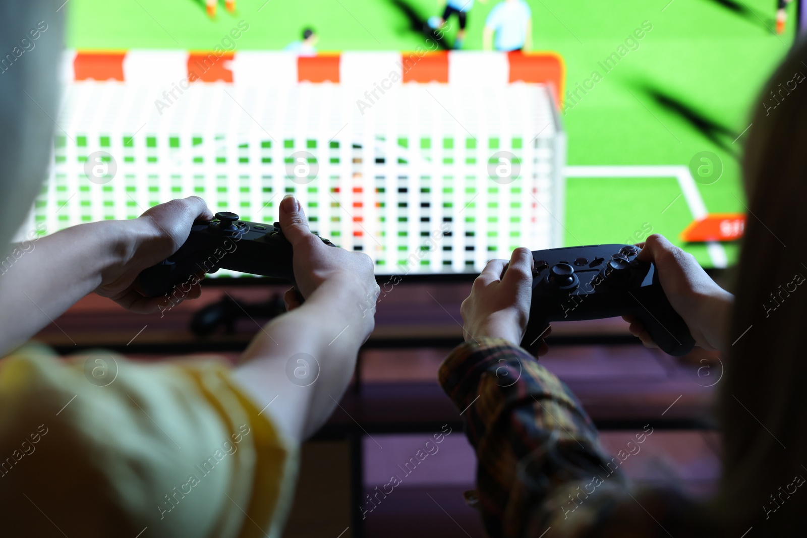 Photo of Mother and her daughter playing video game at home, closeup