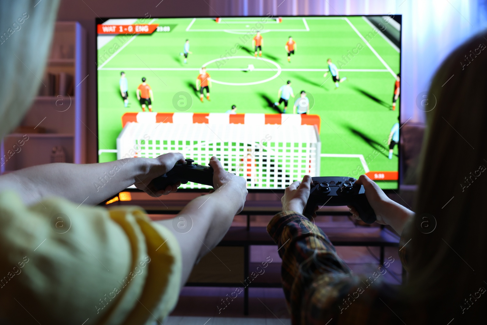 Photo of Mother and her daughter playing video game at home, closeup