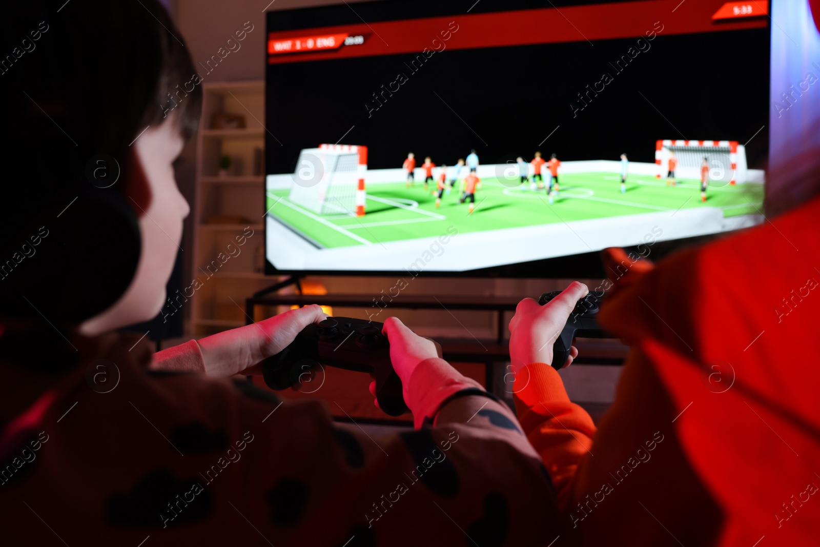 Photo of Little kids playing video game at home, closeup