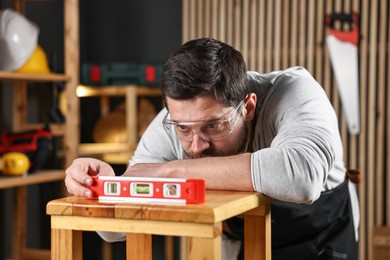 Photo of Professional repairman checking stool level in workshop