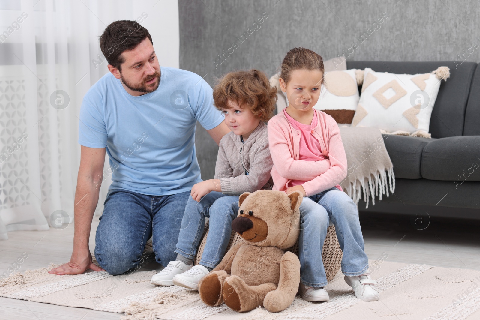 Photo of Resentful little kids and their father arguing at home