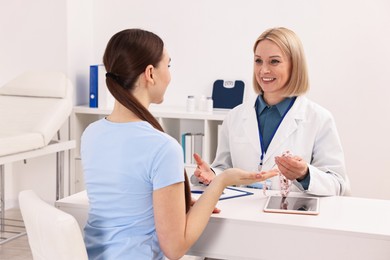 Photo of Weight loss. Smiling nutritionist consulting patient at table in clinic