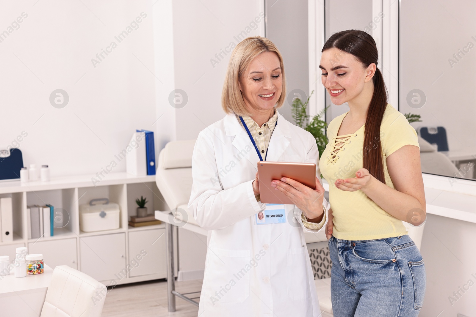 Photo of Weight loss. Smiling nutritionist with tablet consulting patient in clinic, space for text