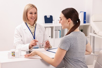 Photo of Weight loss. Smiling nutritionist consulting patient at table in clinic