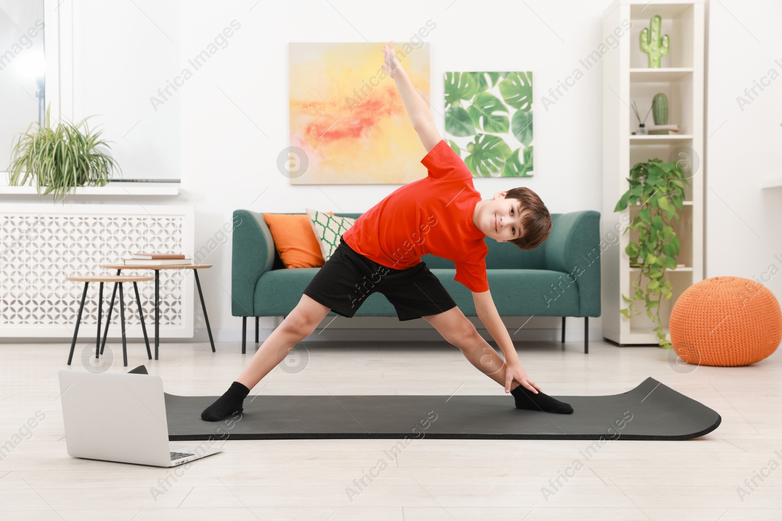 Photo of Boy having training with online coach via laptop at home