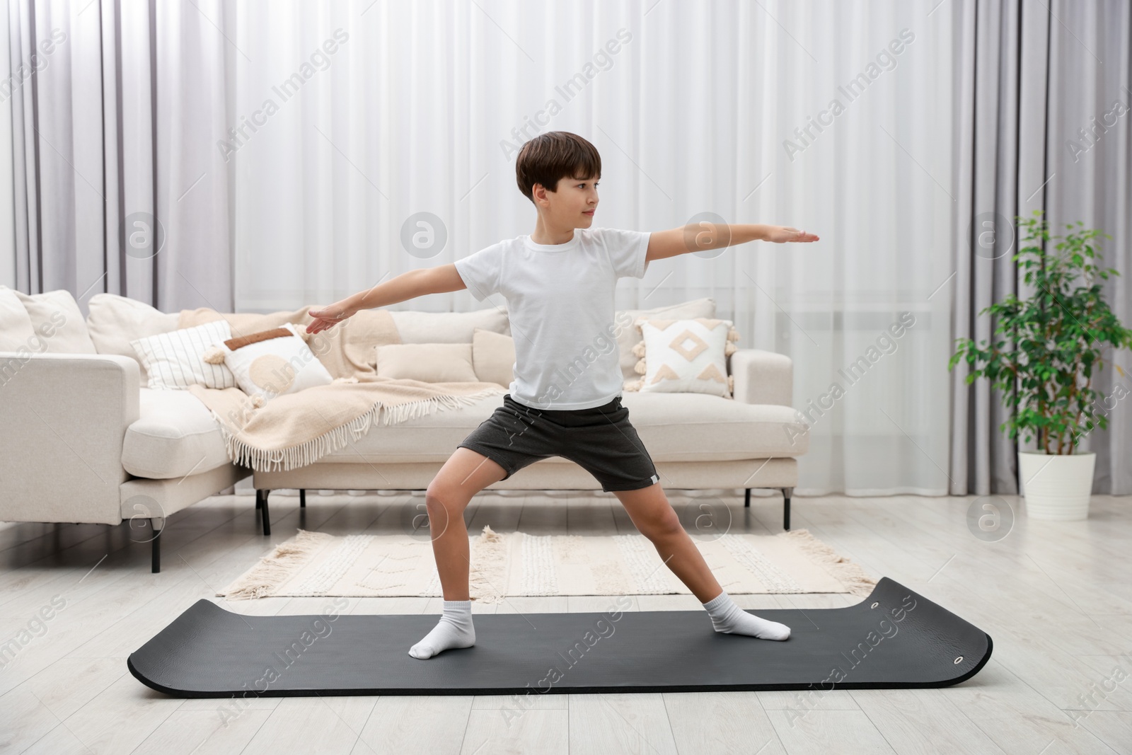 Photo of Boy doing exercise on fitness mat at home. Sport activity