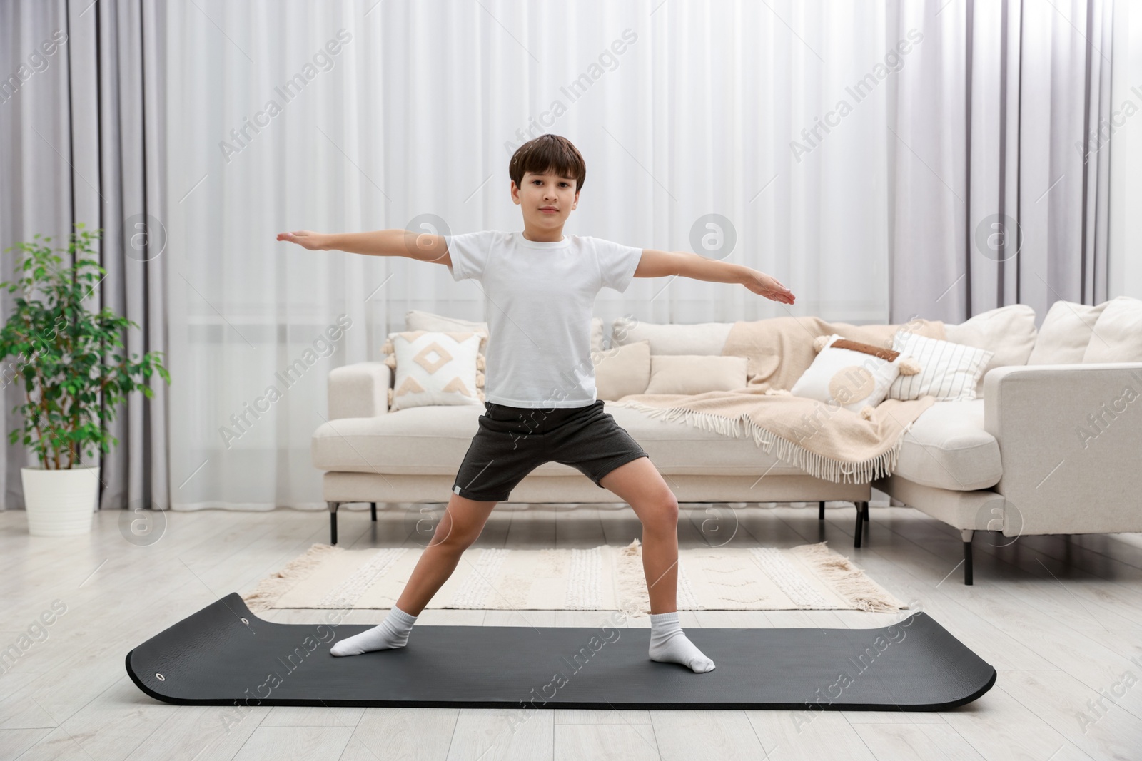 Photo of Boy doing exercise on fitness mat at home. Sport activity