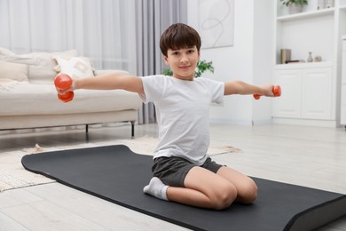 Photo of Boy training with dumbbells at home. Sport activity