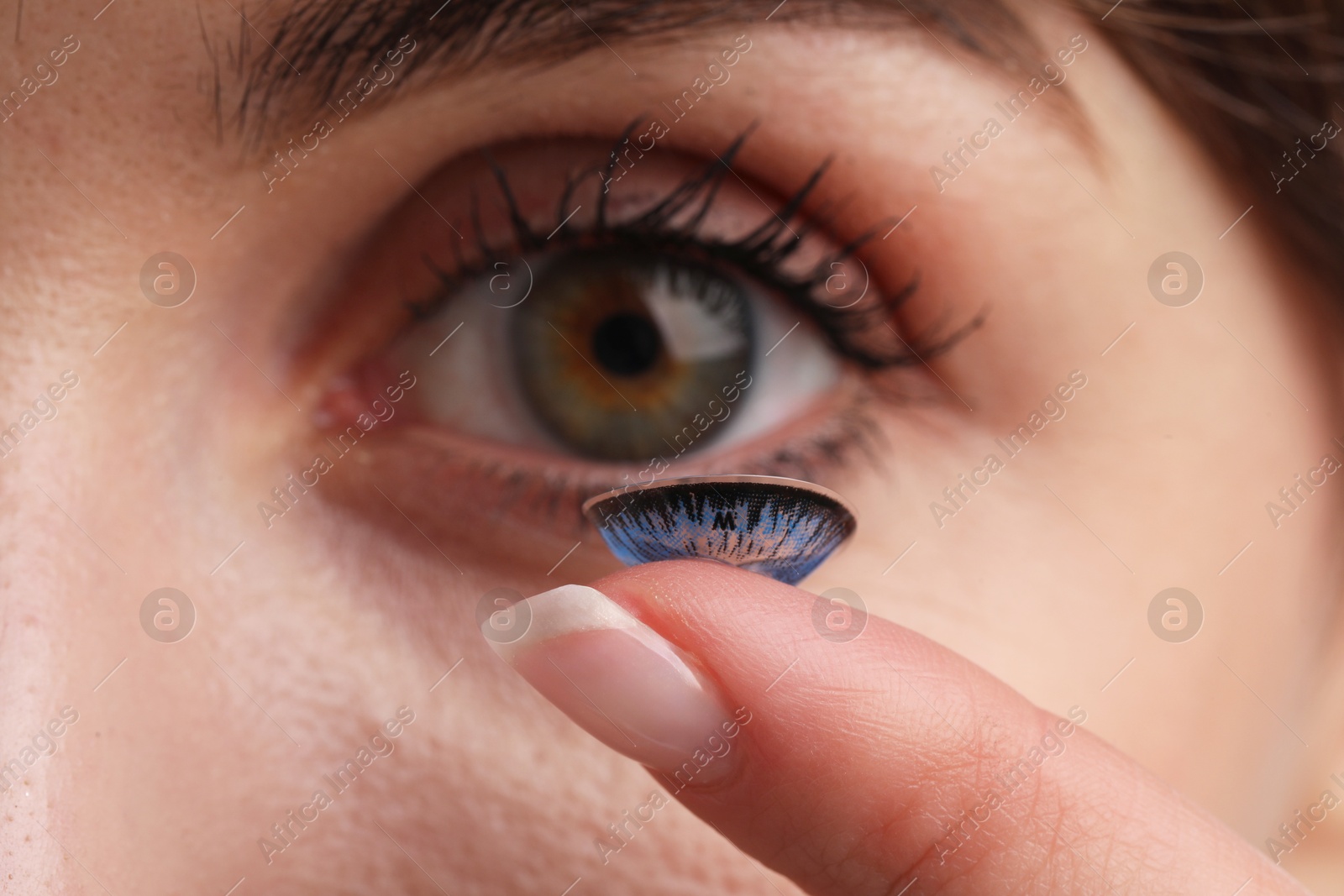 Photo of Woman with blue color contact lens, closeup. Selective focus