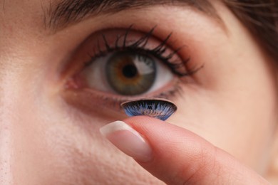 Photo of Woman with blue color contact lens, closeup. Selective focus