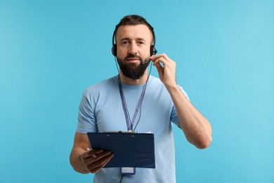 Photo of Technical support call center. Operator with clipboard on light blue background