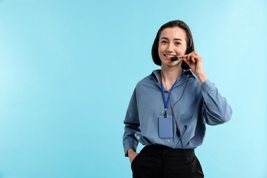 Photo of Technical support call center. Smiling operator on light blue background. Space for text