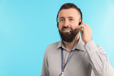 Photo of Technical support call center. Smiling operator on light blue background. Space for text