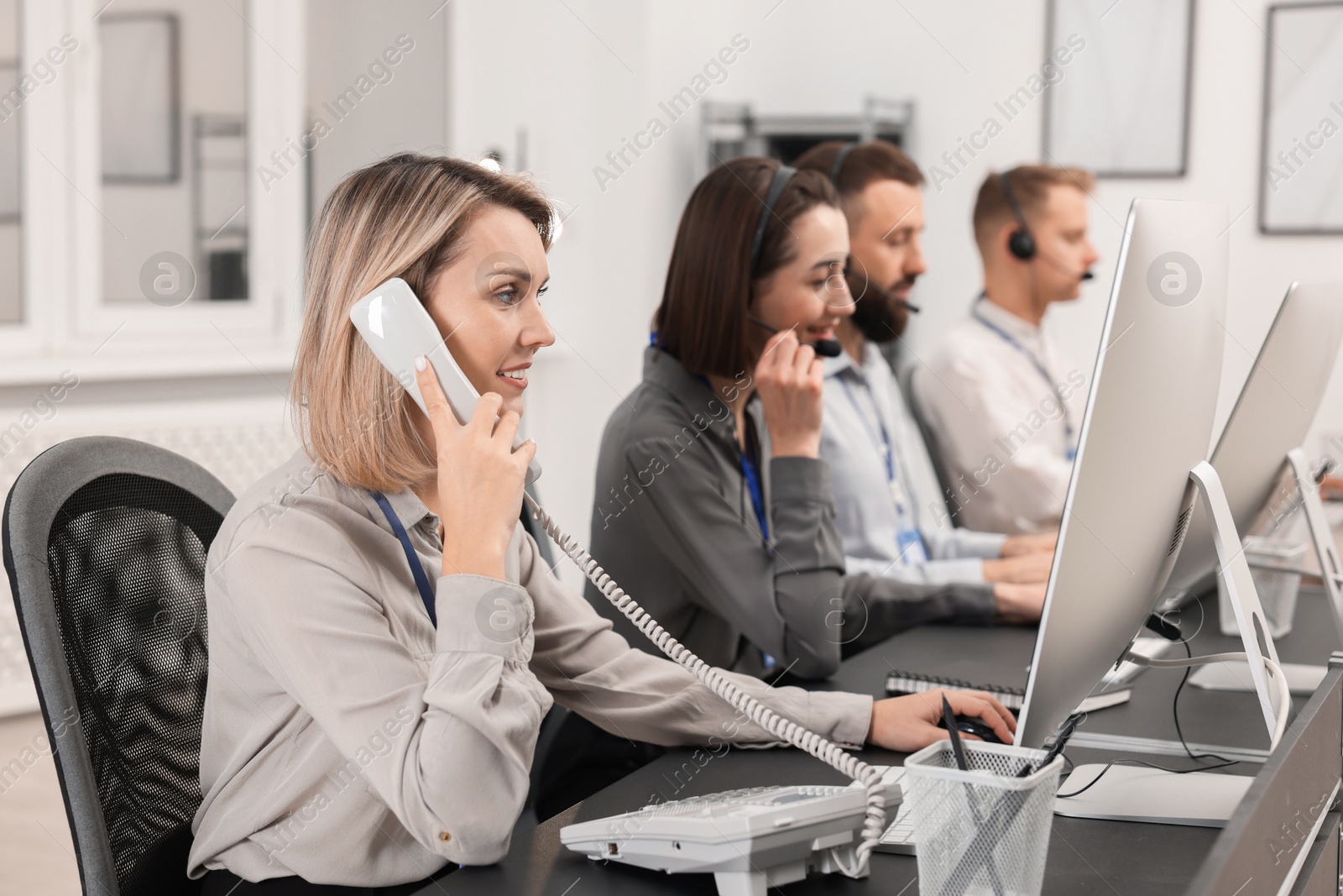 Photo of Technical support call center. Team of operators working in office