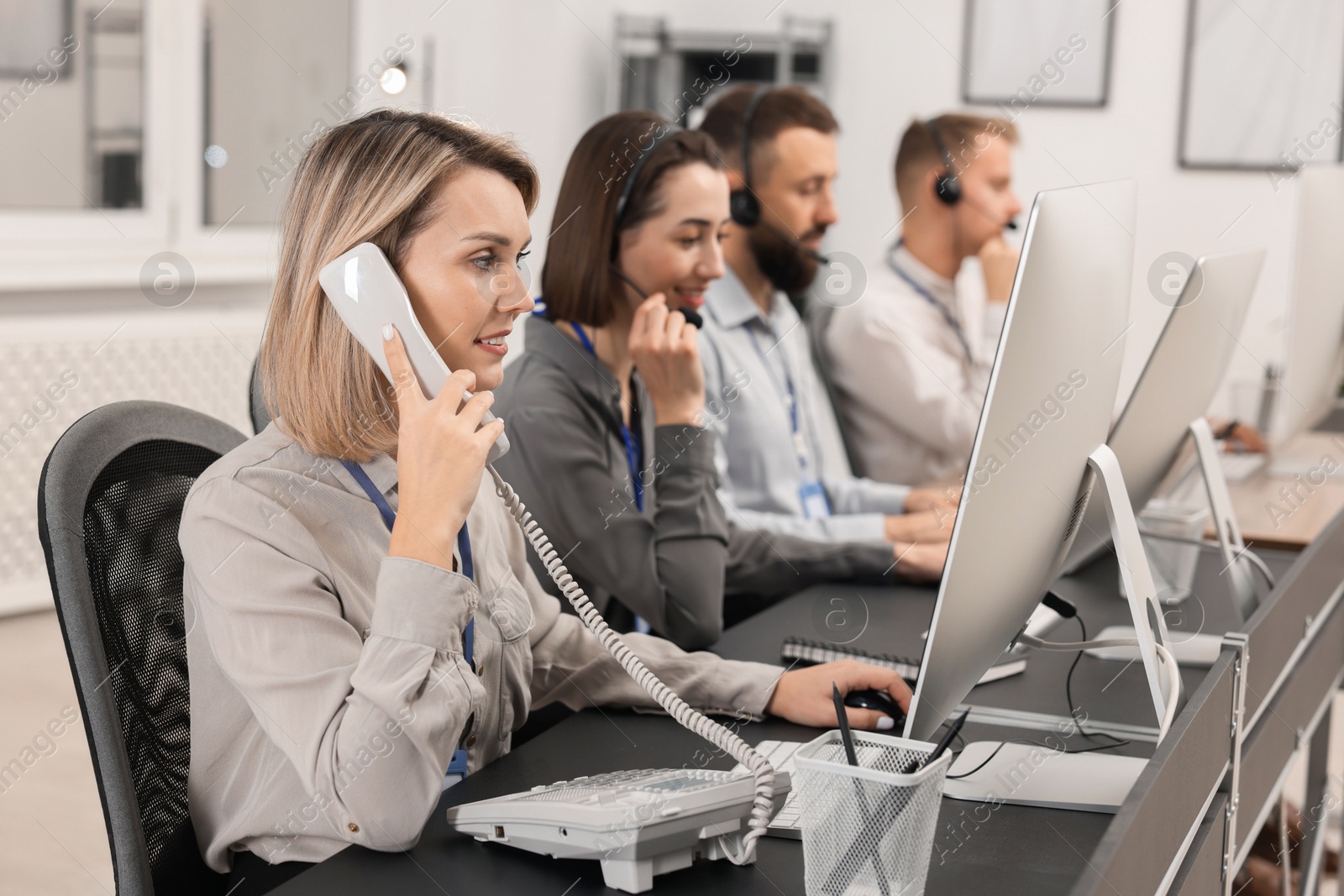 Photo of Technical support call center. Team of operators working in office