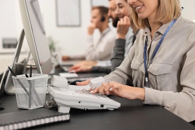 Photo of Technical support call center. Team of operators working at table in office, closeup