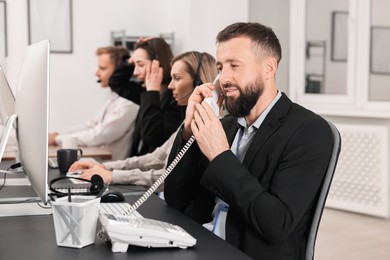 Photo of Technical support call center. Team of operators working in office