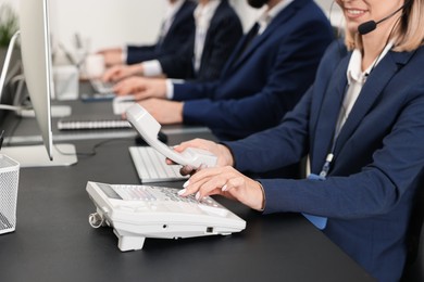 Photo of Technical support call center. Team of operators working at table in office, closeup