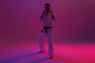 Photo of Karate fighter wearing uniform in color lights