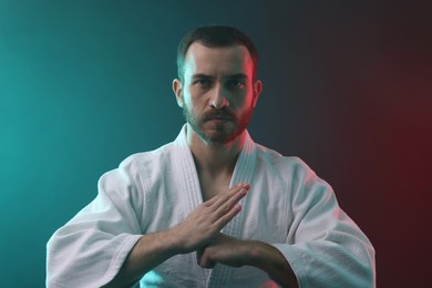 Photo of Karate fighter wearing uniform in color lights