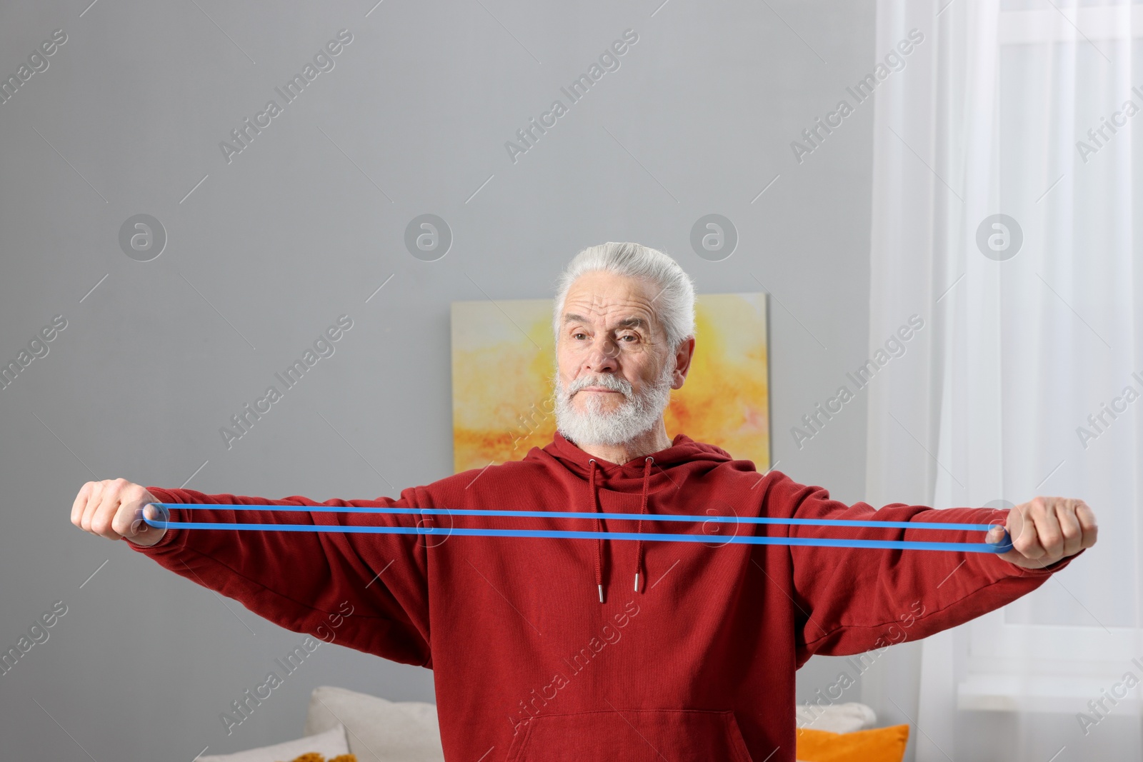 Photo of Elderly man exercising with dumbbells at home