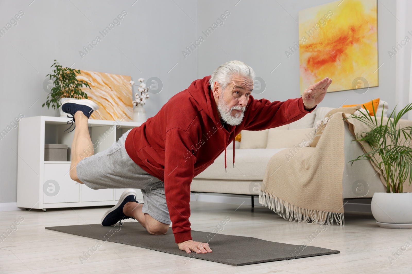 Photo of Elderly man exercising at home. Healthy leisure