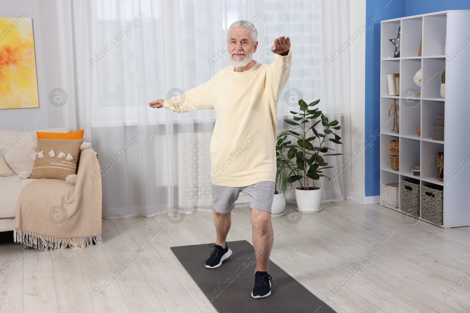 Photo of Elderly man exercising at home. Healthy leisure