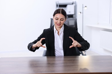 Photo of Beautiful woman showing something at wooden table in office