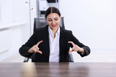 Photo of Beautiful woman showing something at wooden table in office