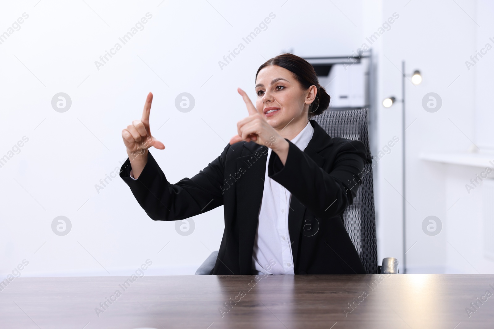 Photo of Beautiful woman showing something at wooden table in office