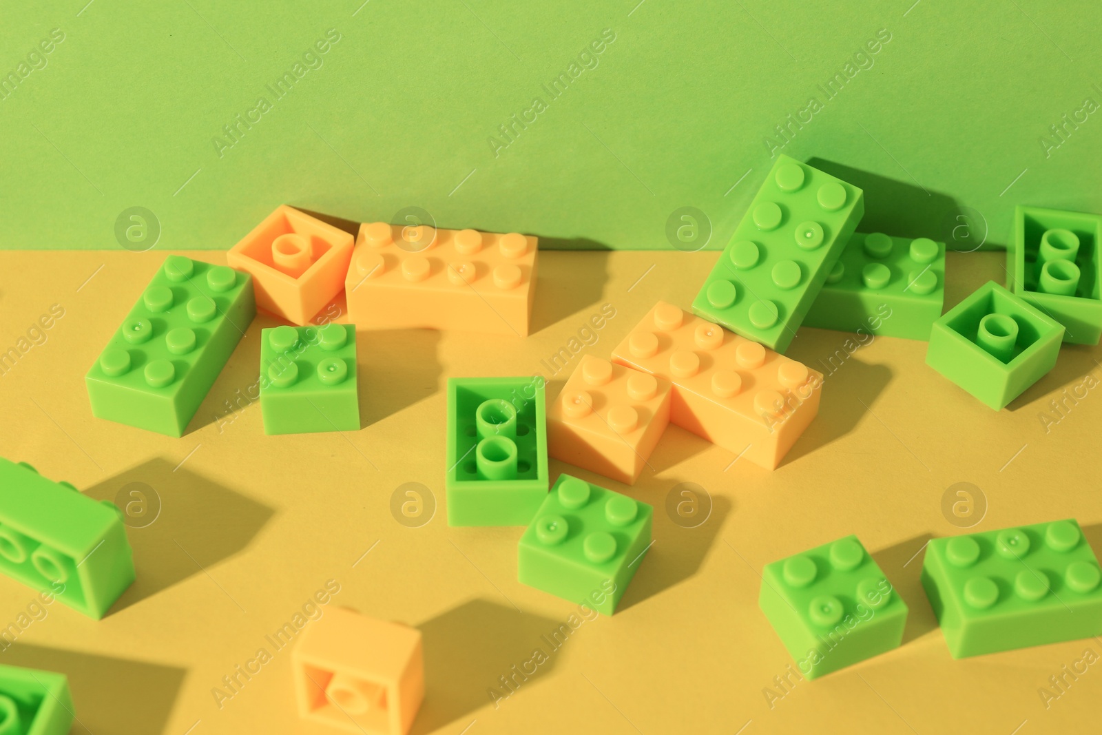 Photo of Construction toy. Colorful building bricks on color background, closeup