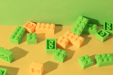 Photo of Construction toy. Colorful building bricks on color background, closeup