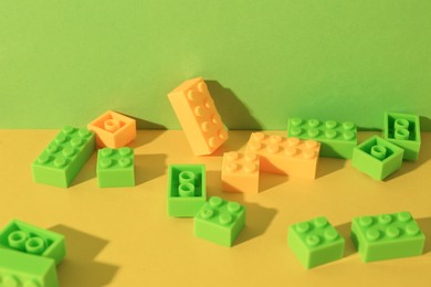 Photo of Construction toy. Colorful building bricks on color background, closeup