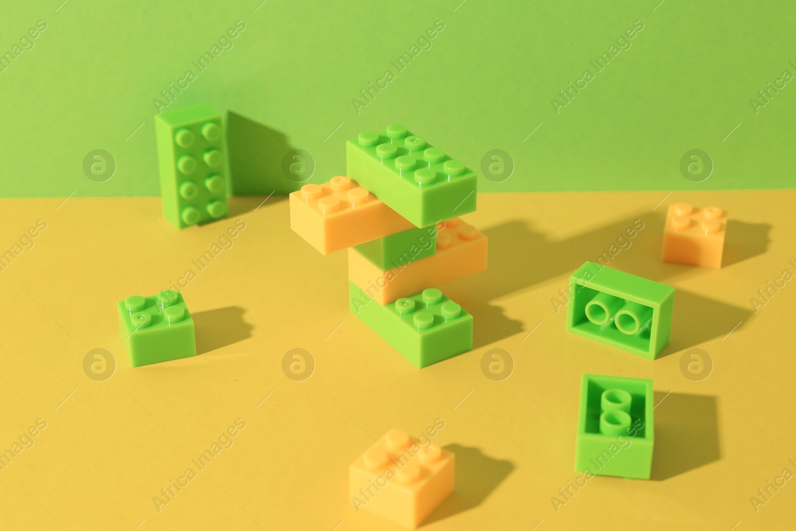 Photo of Construction toy. Colorful building bricks on color background, closeup